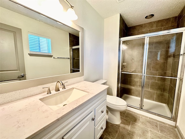 bathroom with vanity, a textured ceiling, an enclosed shower, toilet, and tile patterned floors