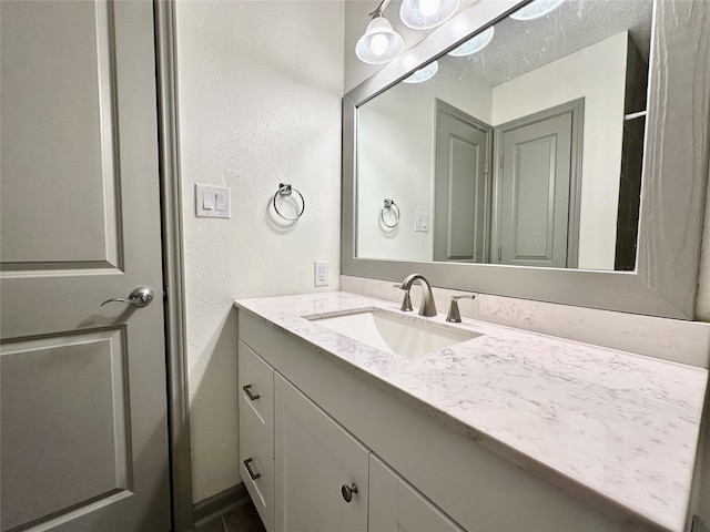 bathroom featuring a textured ceiling and vanity