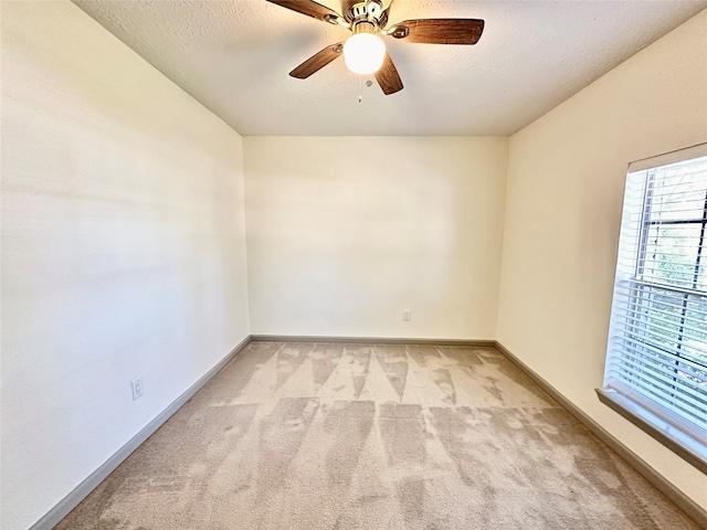 carpeted empty room featuring a textured ceiling and ceiling fan