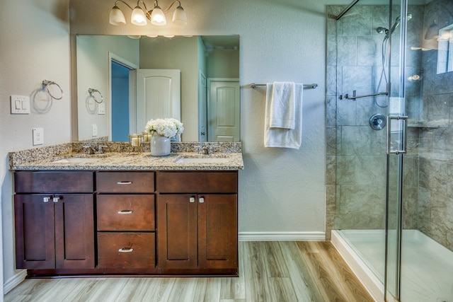 bathroom featuring a shower with shower door, hardwood / wood-style flooring, and vanity