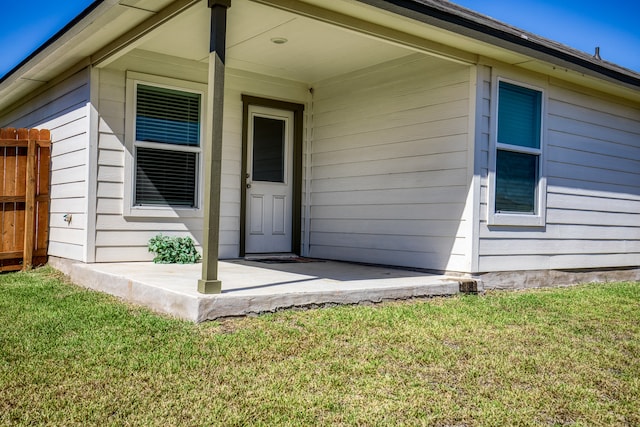 view of exterior entry with a lawn