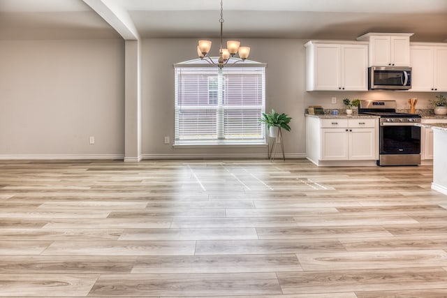 kitchen featuring appliances with stainless steel finishes, a notable chandelier, light hardwood / wood-style flooring, and white cabinets