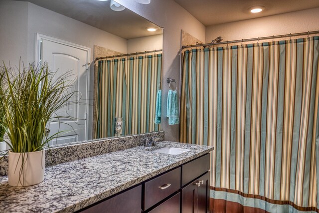 bathroom with walk in shower and vanity