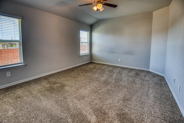 carpeted empty room featuring vaulted ceiling and ceiling fan