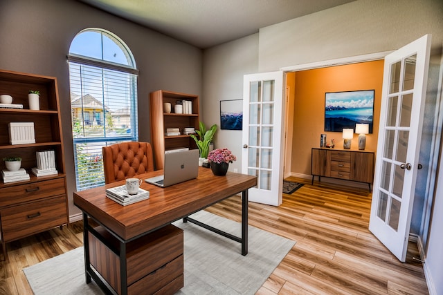 home office featuring light hardwood / wood-style flooring, french doors, and a wealth of natural light