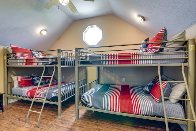 bedroom with ceiling fan, hardwood / wood-style flooring, lofted ceiling, and a textured ceiling