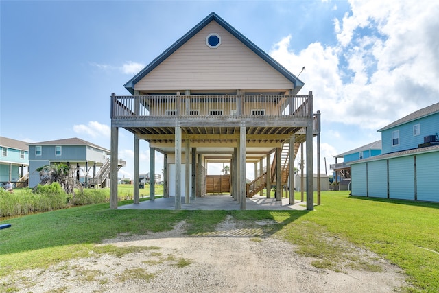 back of property with a wooden deck, a yard, and a carport