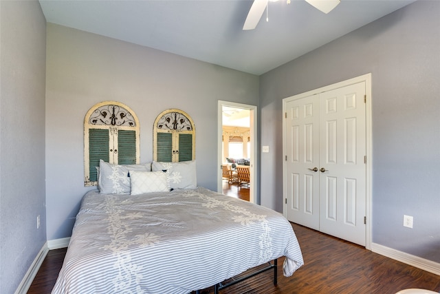 bedroom with dark wood-type flooring, ceiling fan, and a closet