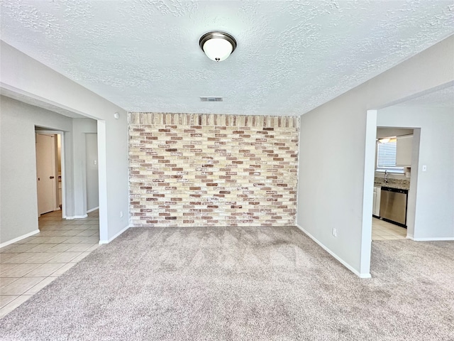 carpeted spare room featuring a textured ceiling and sink