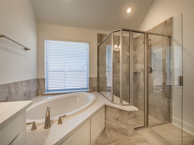 bathroom featuring shower with separate bathtub, vaulted ceiling, and vanity