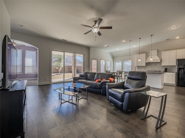 living room with dark wood-type flooring, ceiling fan, and sink