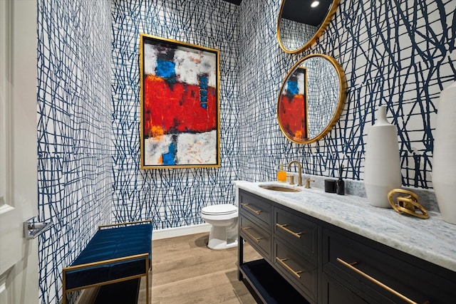 bathroom with vanity, toilet, and wood-type flooring