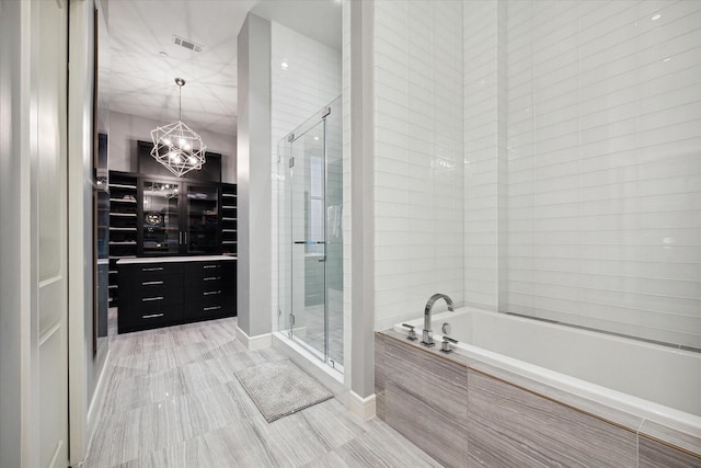 bathroom featuring a notable chandelier and plus walk in shower