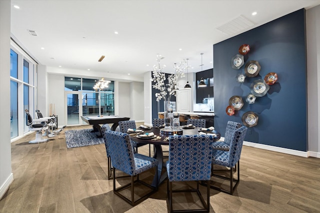 dining room with pool table, a chandelier, and hardwood / wood-style flooring