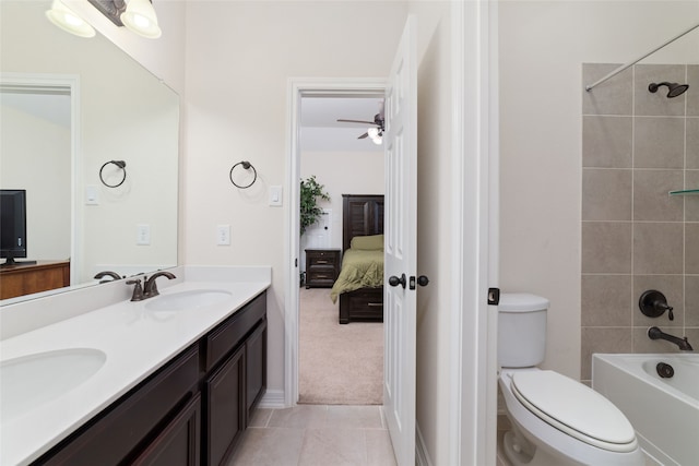 full bathroom featuring tiled shower / bath, tile patterned flooring, ceiling fan, toilet, and vanity