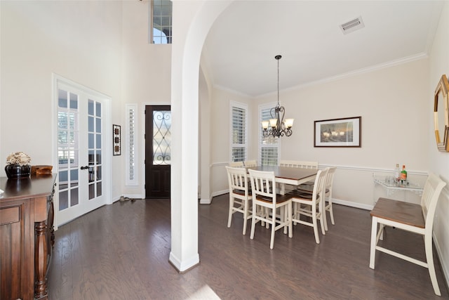 dining space with french doors, an inviting chandelier, crown molding, and dark hardwood / wood-style floors