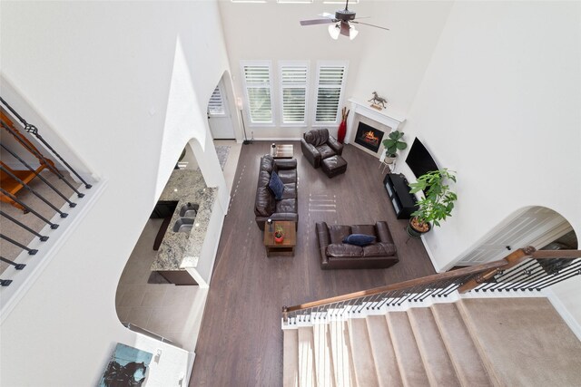 living room with ceiling fan and a towering ceiling