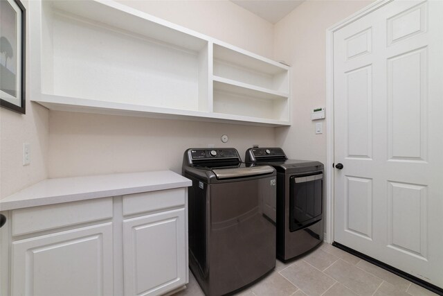 laundry area featuring washer and dryer and light tile patterned floors