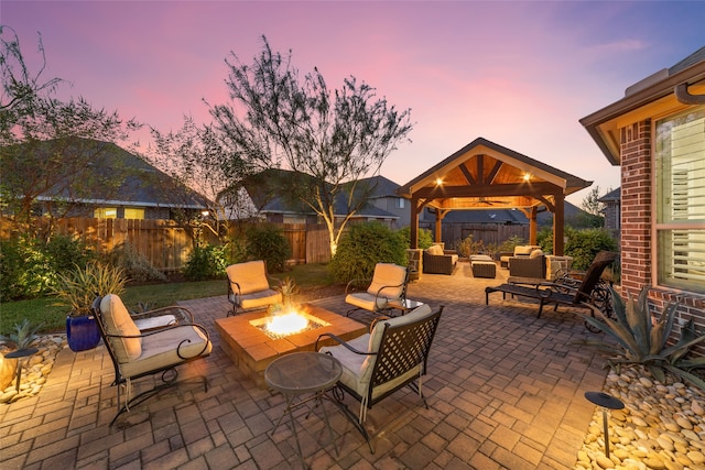 patio terrace at dusk featuring a gazebo and an outdoor living space with a fire pit