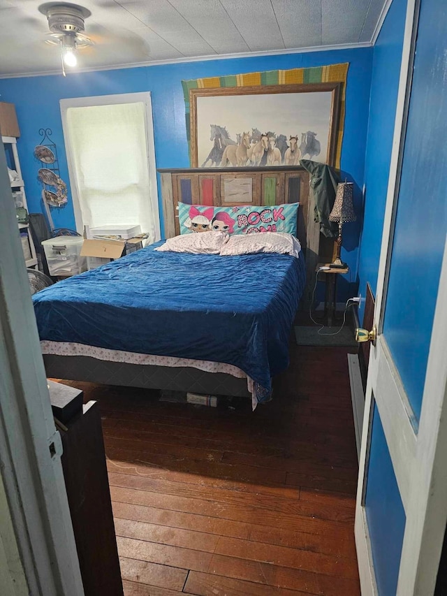 bedroom featuring ceiling fan, dark wood-type flooring, and ornamental molding