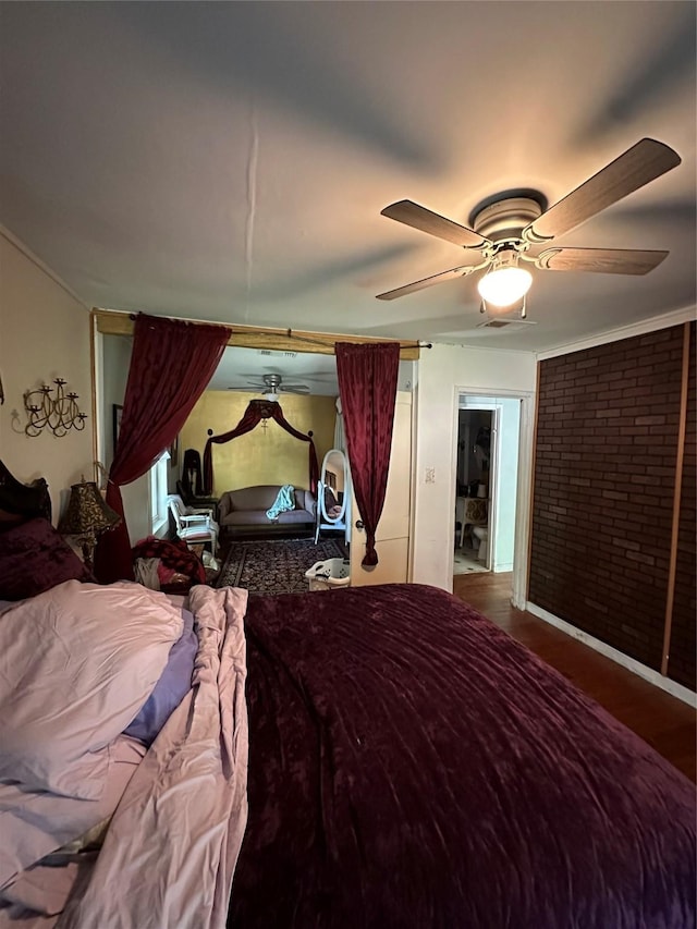 bedroom featuring hardwood / wood-style floors, ceiling fan, and brick wall