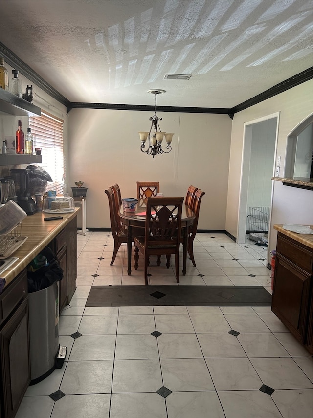 tiled dining space with a notable chandelier, a textured ceiling, and ornamental molding