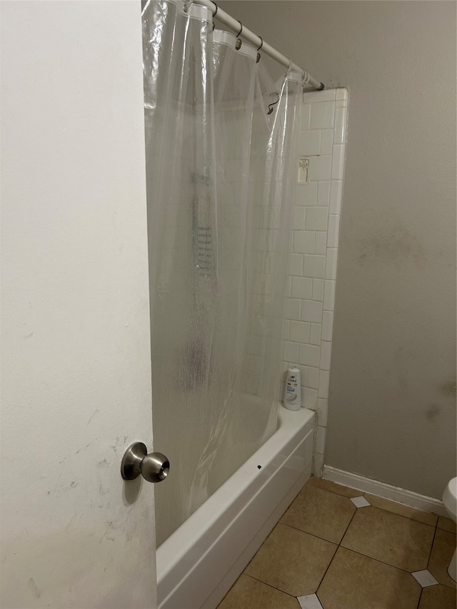 bathroom featuring shower / tub combo with curtain, toilet, and tile patterned floors