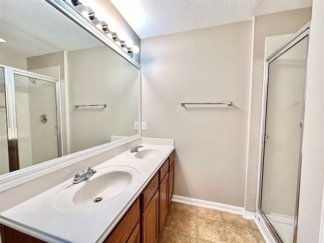 bathroom with tile patterned floors, an enclosed shower, vanity, and a textured ceiling