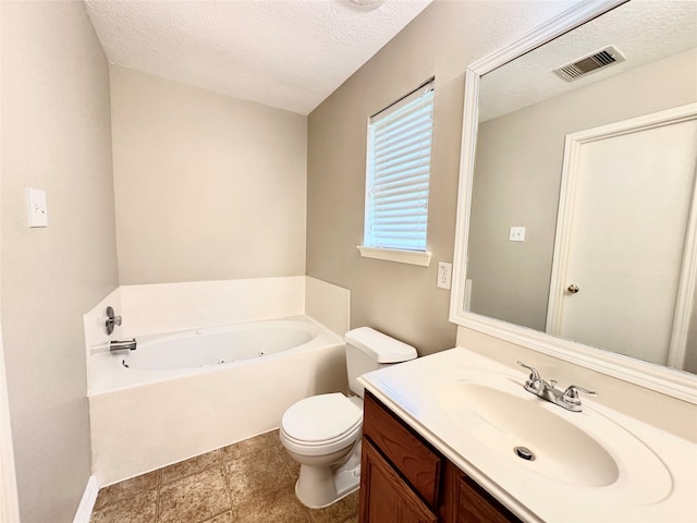 bathroom with a tub to relax in, a textured ceiling, vanity, and toilet