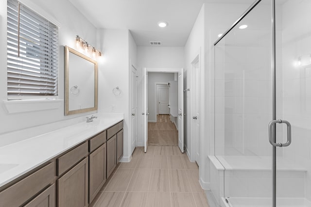 bathroom with tile patterned floors, vanity, and a shower with door