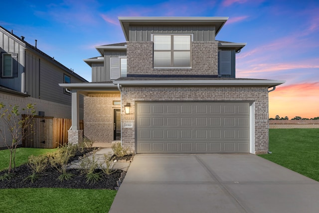 view of front of home with a garage and a lawn