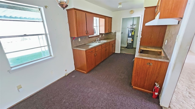 kitchen featuring dark carpet, water heater, sink, and tasteful backsplash