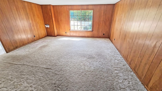 empty room with light colored carpet and wood walls