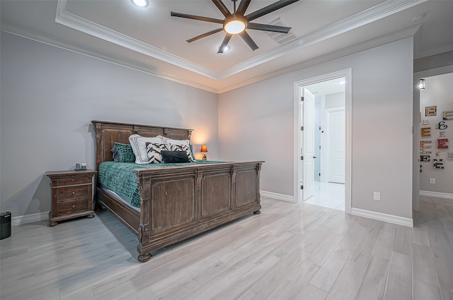 bedroom with ceiling fan, a tray ceiling, ornamental molding, and light hardwood / wood-style flooring