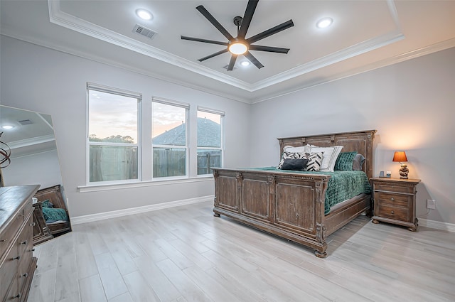 bedroom with light hardwood / wood-style floors, a mountain view, ceiling fan, a tray ceiling, and crown molding