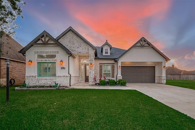 view of front of property with a garage and a lawn