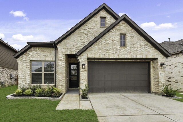 french country home featuring a front yard and a garage