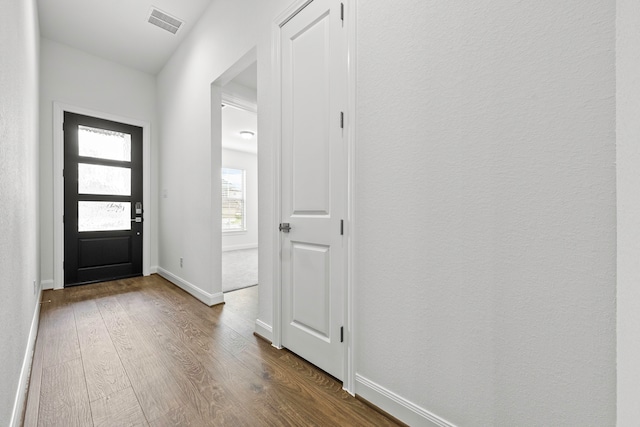 foyer with visible vents, baseboards, and dark wood-style flooring