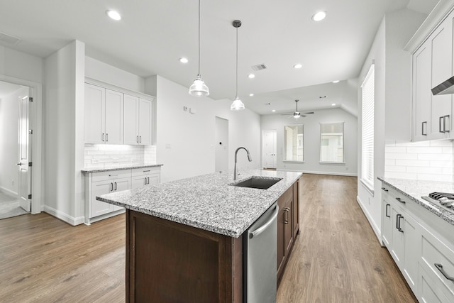 kitchen with appliances with stainless steel finishes, sink, white cabinets, and backsplash