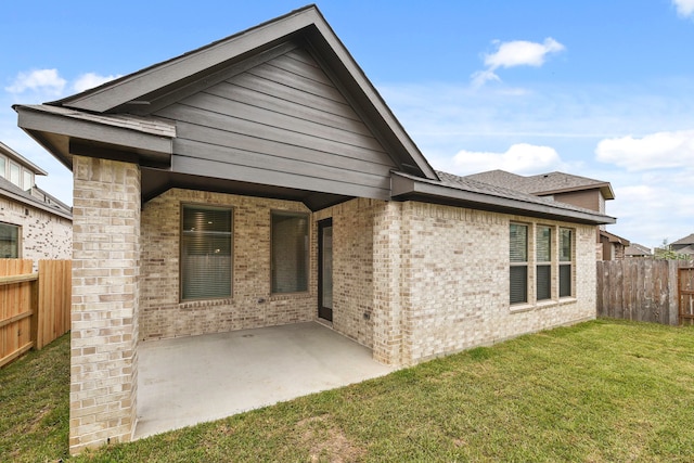 rear view of house featuring a patio area and a lawn