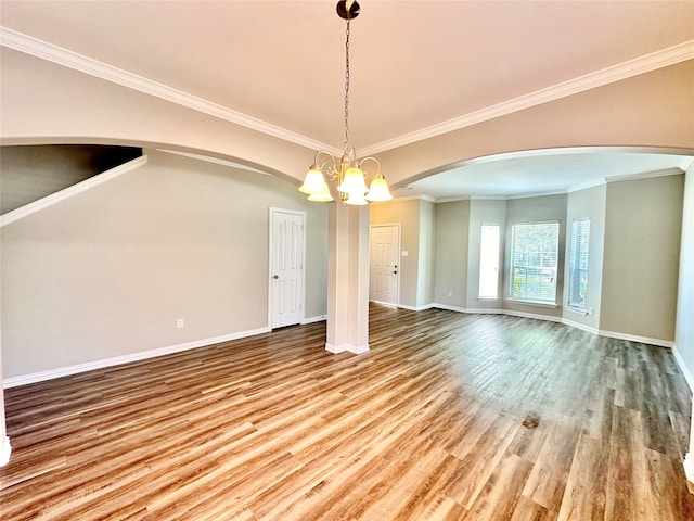 unfurnished room featuring ornamental molding, a chandelier, and hardwood / wood-style flooring