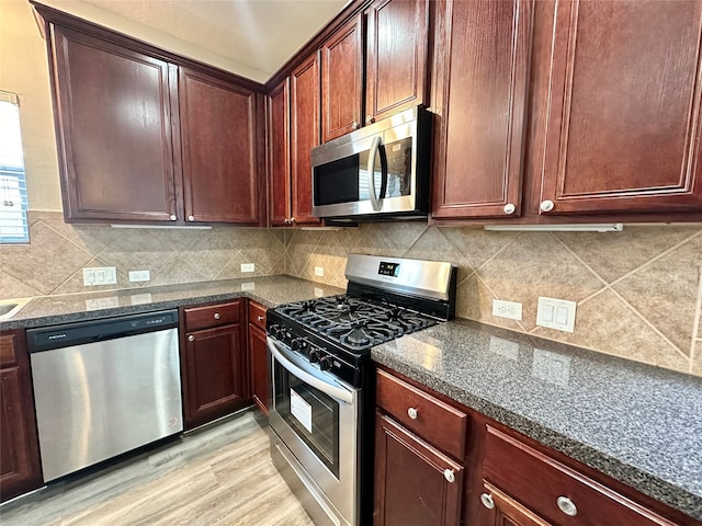 kitchen with backsplash, light hardwood / wood-style floors, and stainless steel appliances