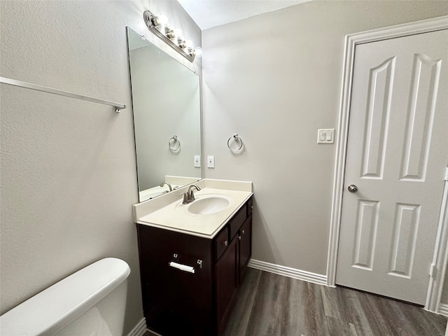 bathroom featuring vanity, hardwood / wood-style floors, and toilet