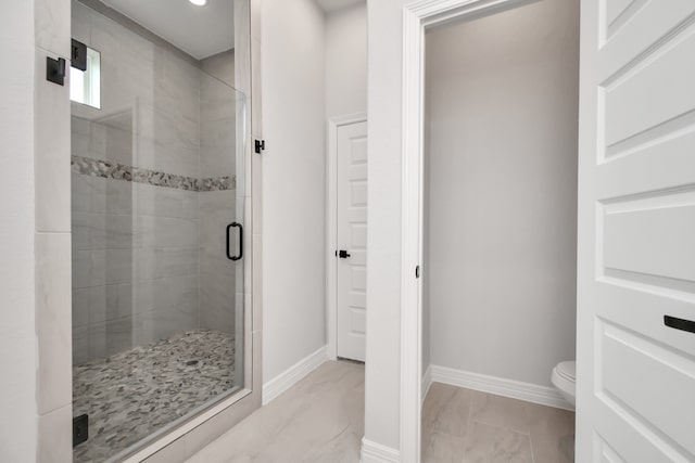 bathroom with toilet and an enclosed shower