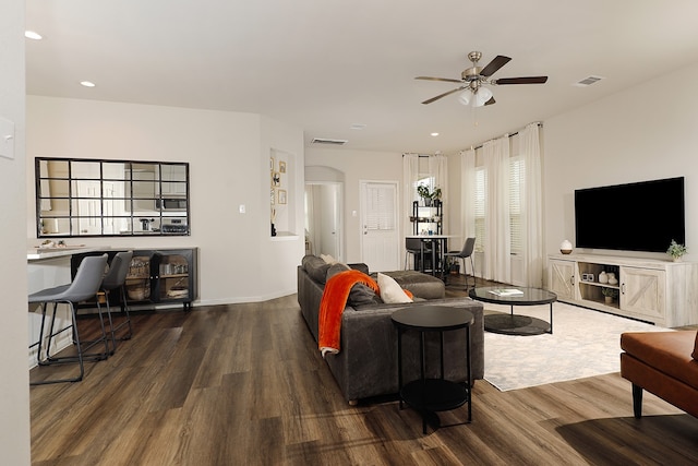 living room with dark hardwood / wood-style flooring and ceiling fan