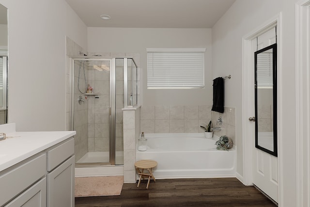 bathroom featuring independent shower and bath, vanity, and wood-type flooring