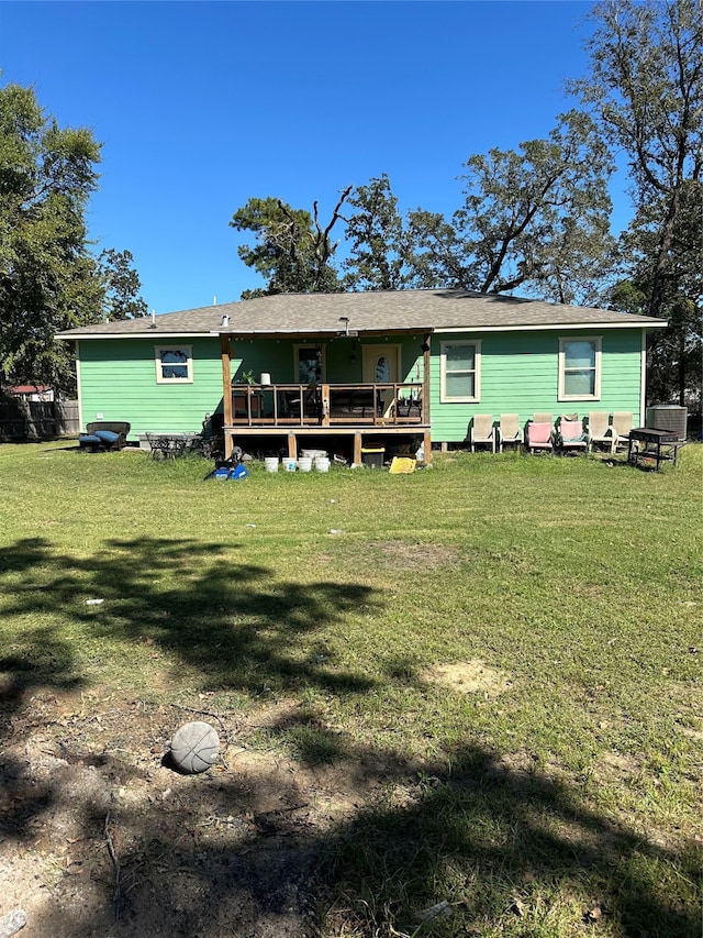 rear view of house with a deck and a yard