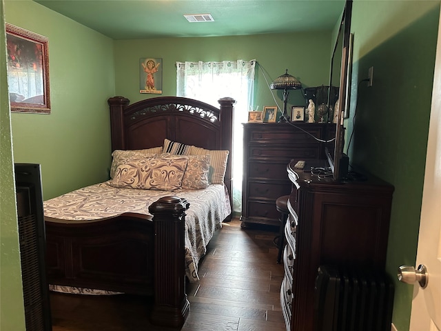 bedroom featuring radiator and dark hardwood / wood-style floors