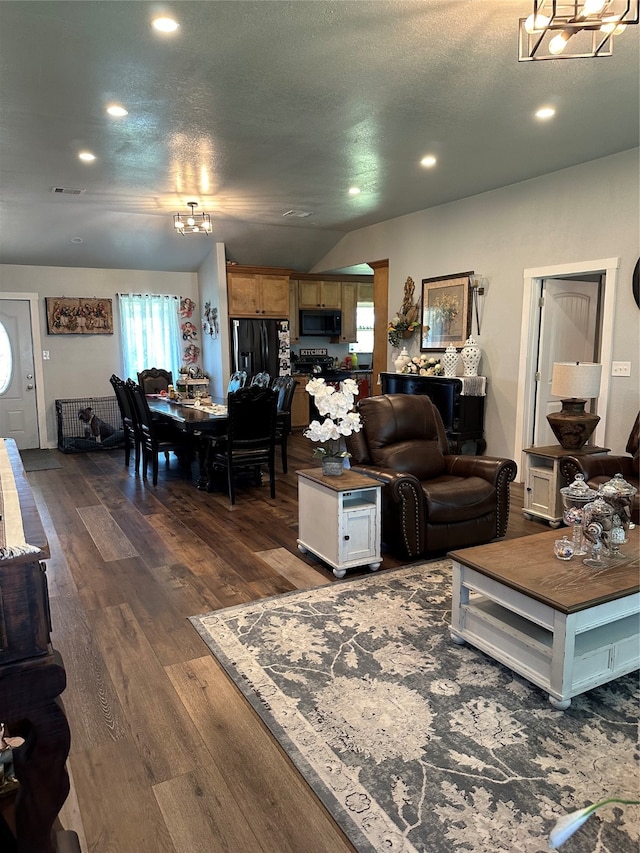 living room featuring vaulted ceiling, a textured ceiling, and dark hardwood / wood-style flooring