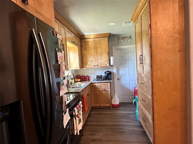 kitchen featuring light stone counters, sink, range with electric cooktop, stainless steel refrigerator, and dark hardwood / wood-style floors